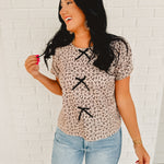 Floral print short sleeved round neck blouse with front black bow tie details in stone/black.