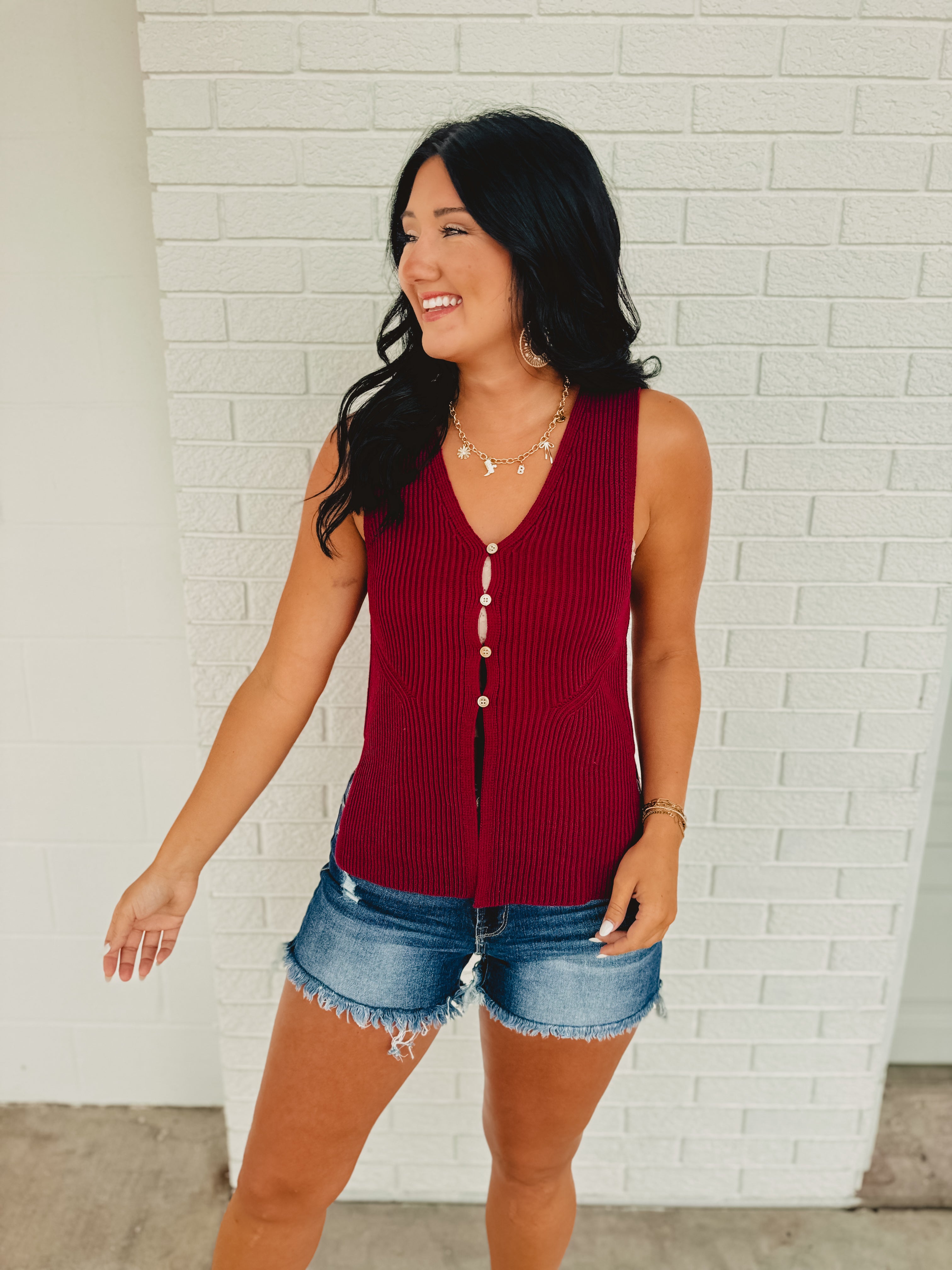 Sleeveless button-up sweater vest in the color cabernet.