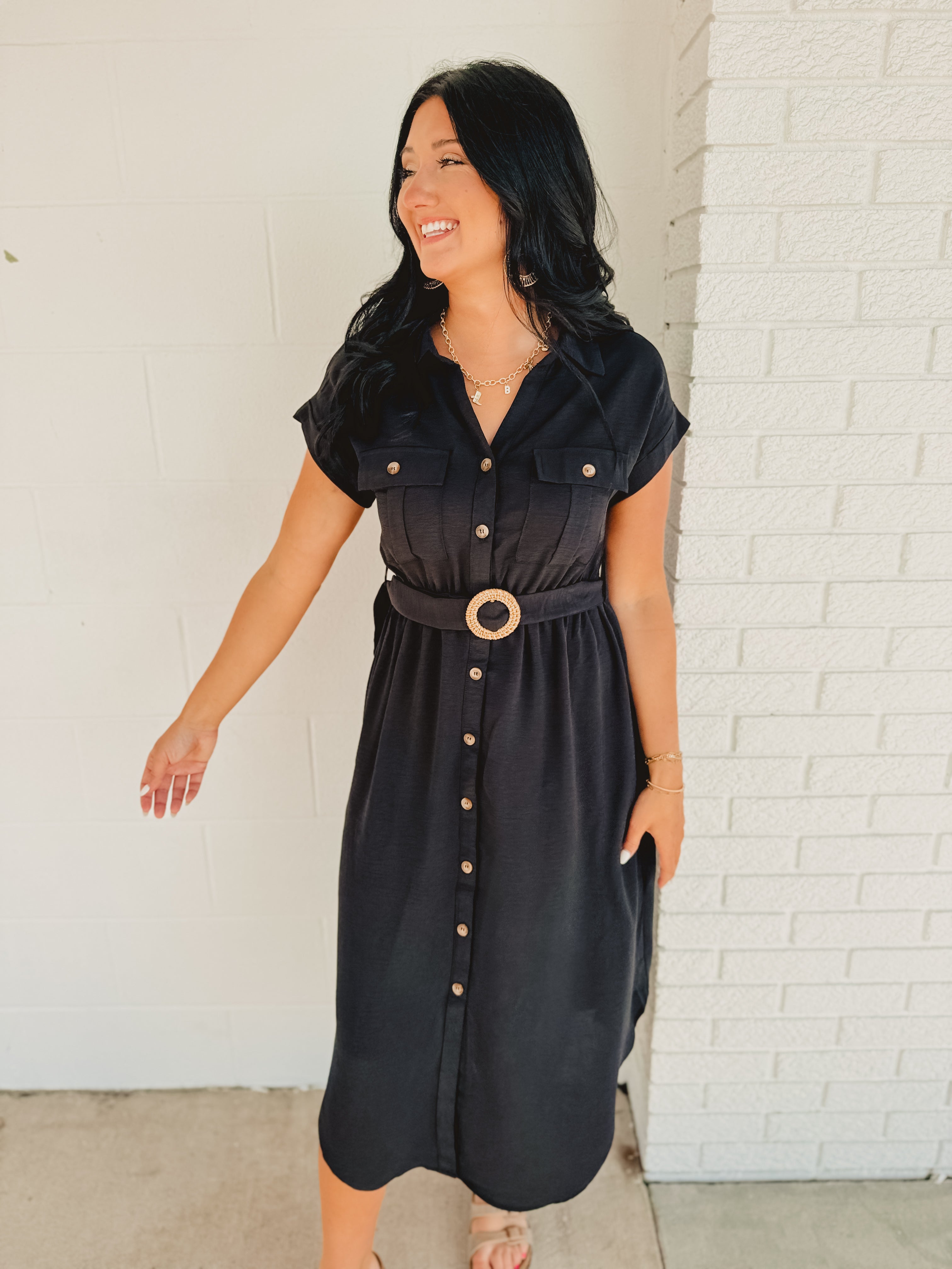 Button down short sleeve black midi dress with belt and front pockets.