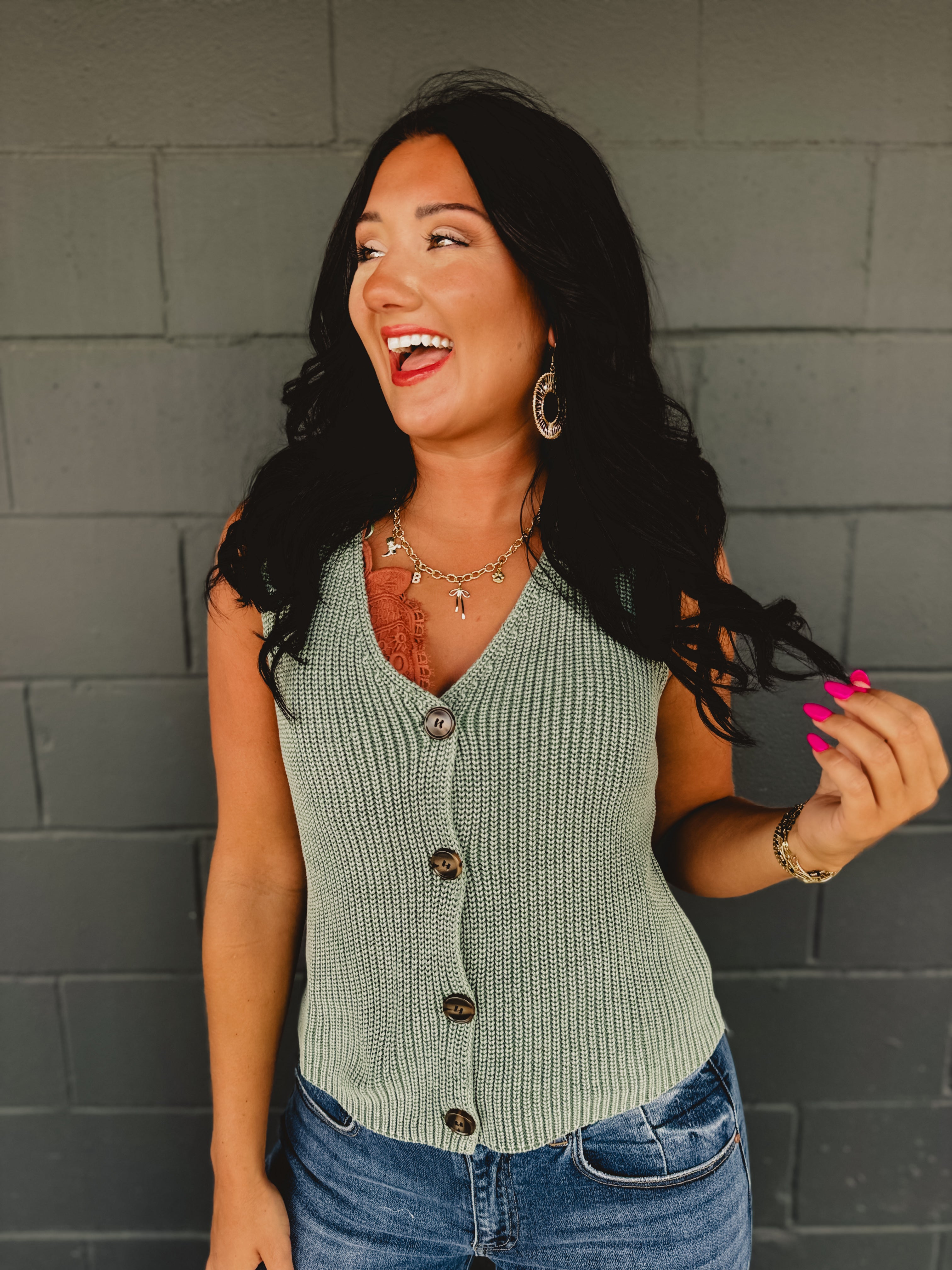 Forest green v-neck knitted sleeveless vest with chunky buttons.