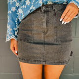 Washed black denim mini cargo skirt with pockets and stretch.