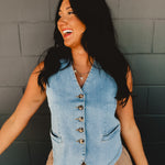 V-neck light wash denim button up sleeveless vest with front pockets.