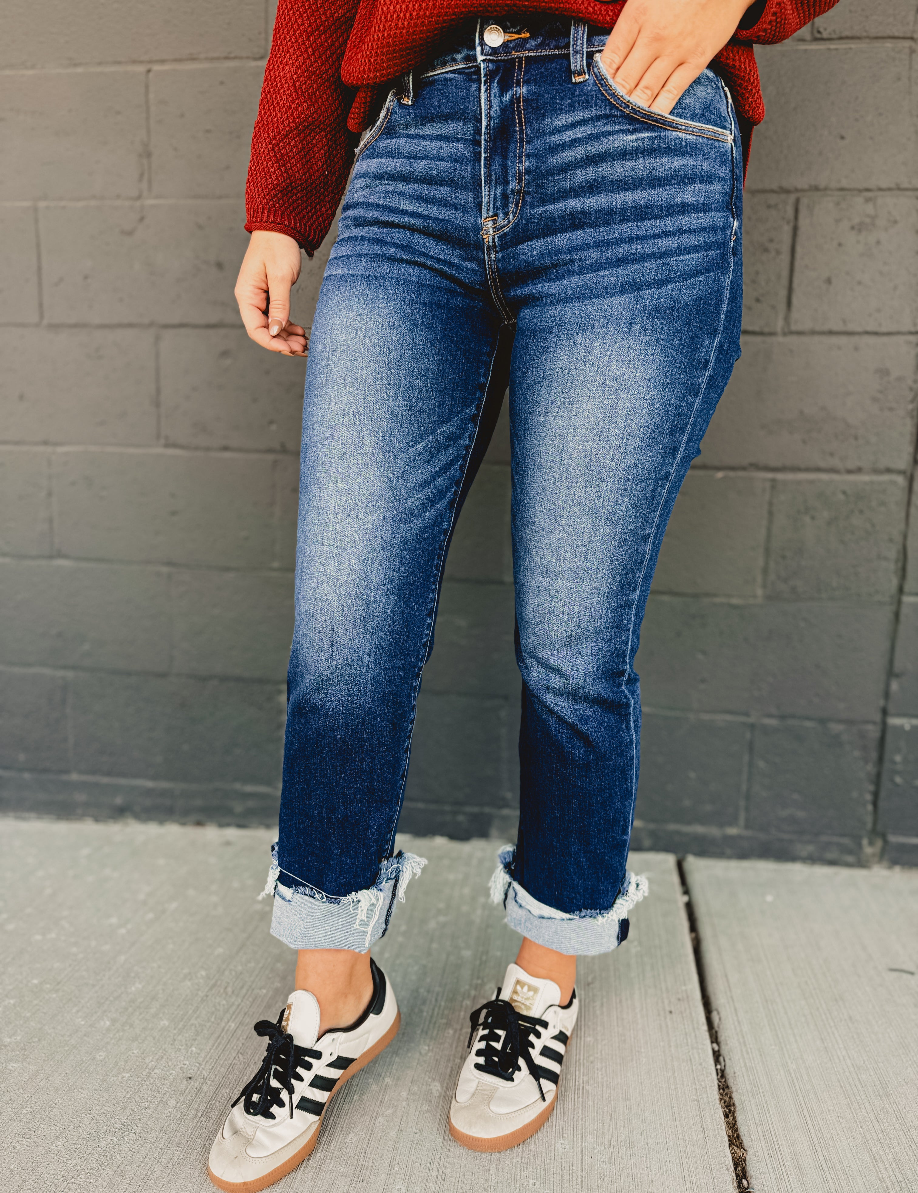 Mid-rise distressed cuffed straight leg jeans in dark denim.