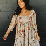 Floral printed babydoll design long sleeve mini dress with a square neckline in the color nude.