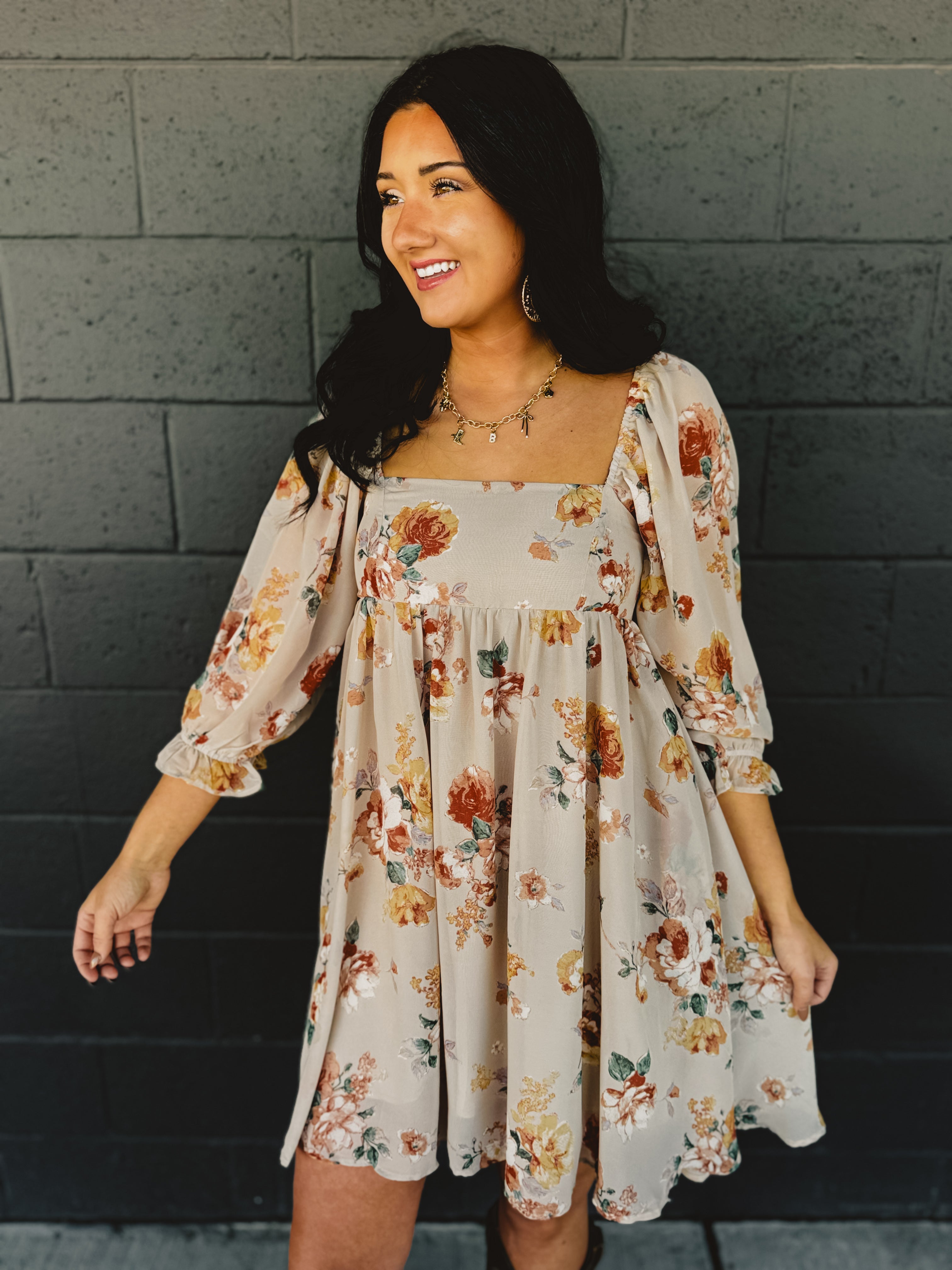 Floral printed babydoll design long sleeve mini dress with a square neckline in the color nude.