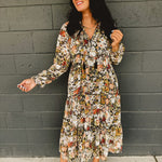 Long sleeve deep v-neck floral tiered midi dress with ruffle hems and tassels in black.