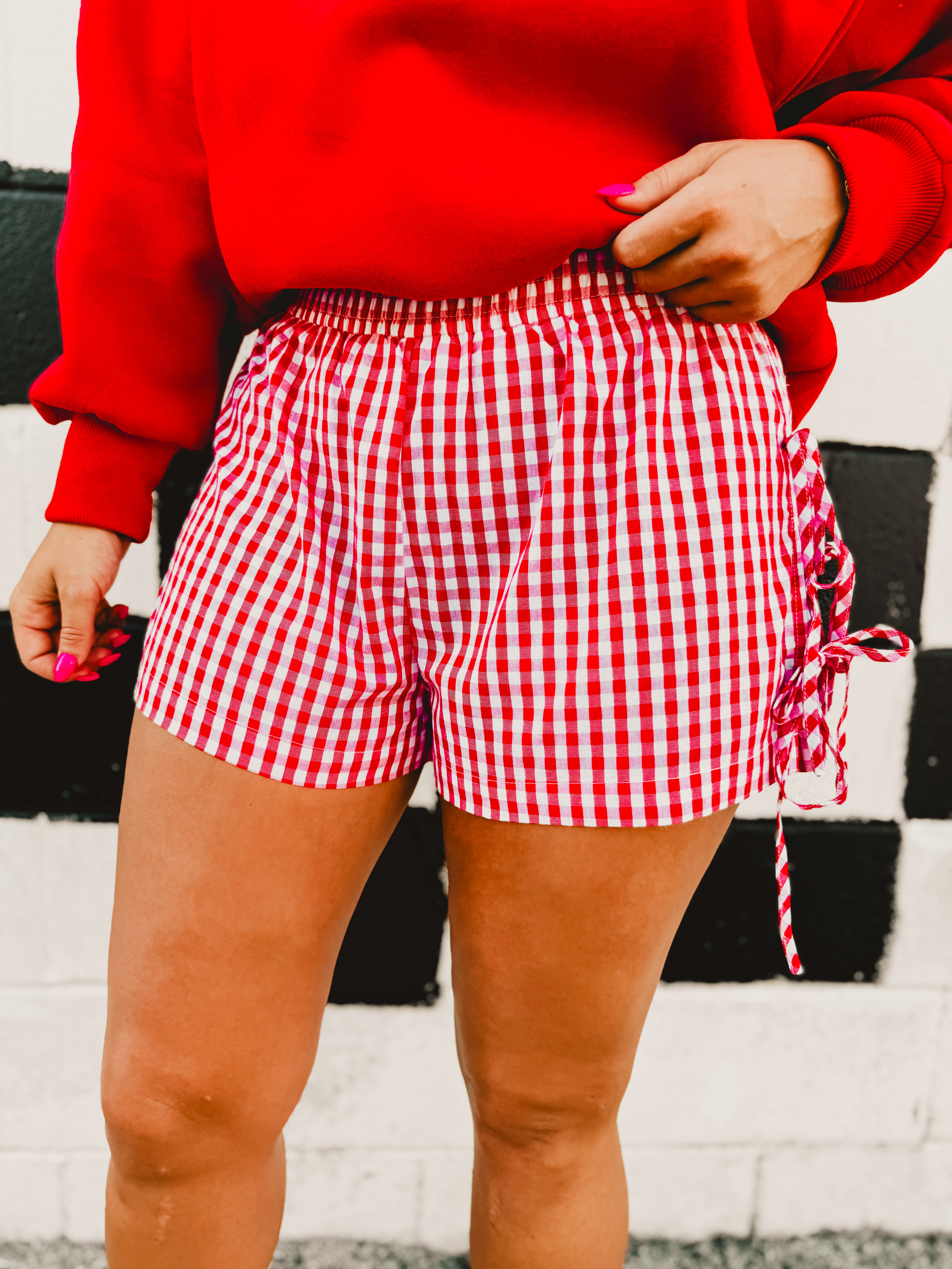 Red and white gingham boxer shorts with side tie details and an elastic waistband.