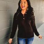 Henley neckline long sleeve waffle knit top in the color black.