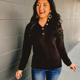 Henley neckline long sleeve waffle knit top in the color black.