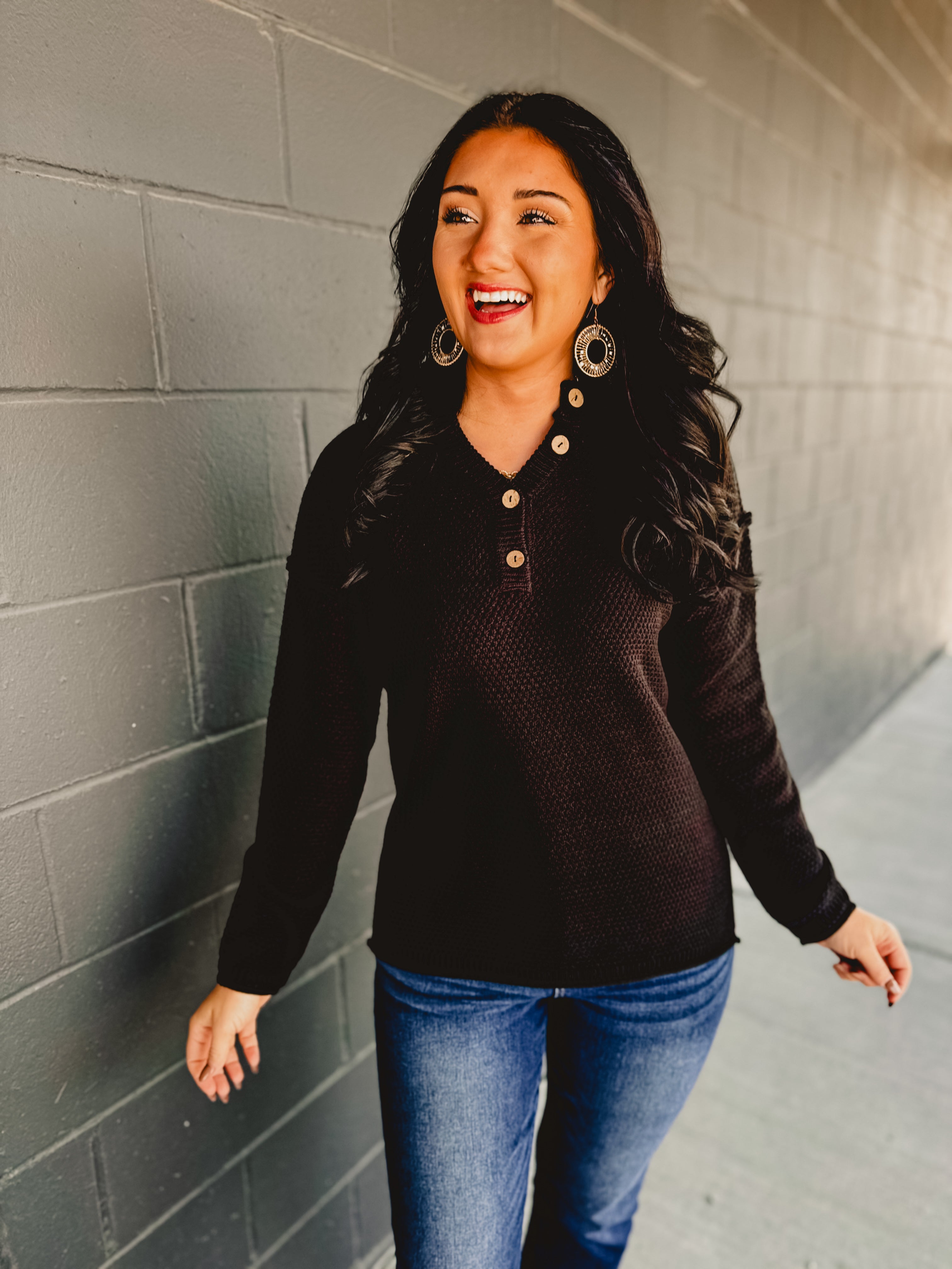 Henley neckline long sleeve waffle knit top in the color black.
