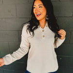 Henley neckline waffle knit long sleeve top in the color bone.
