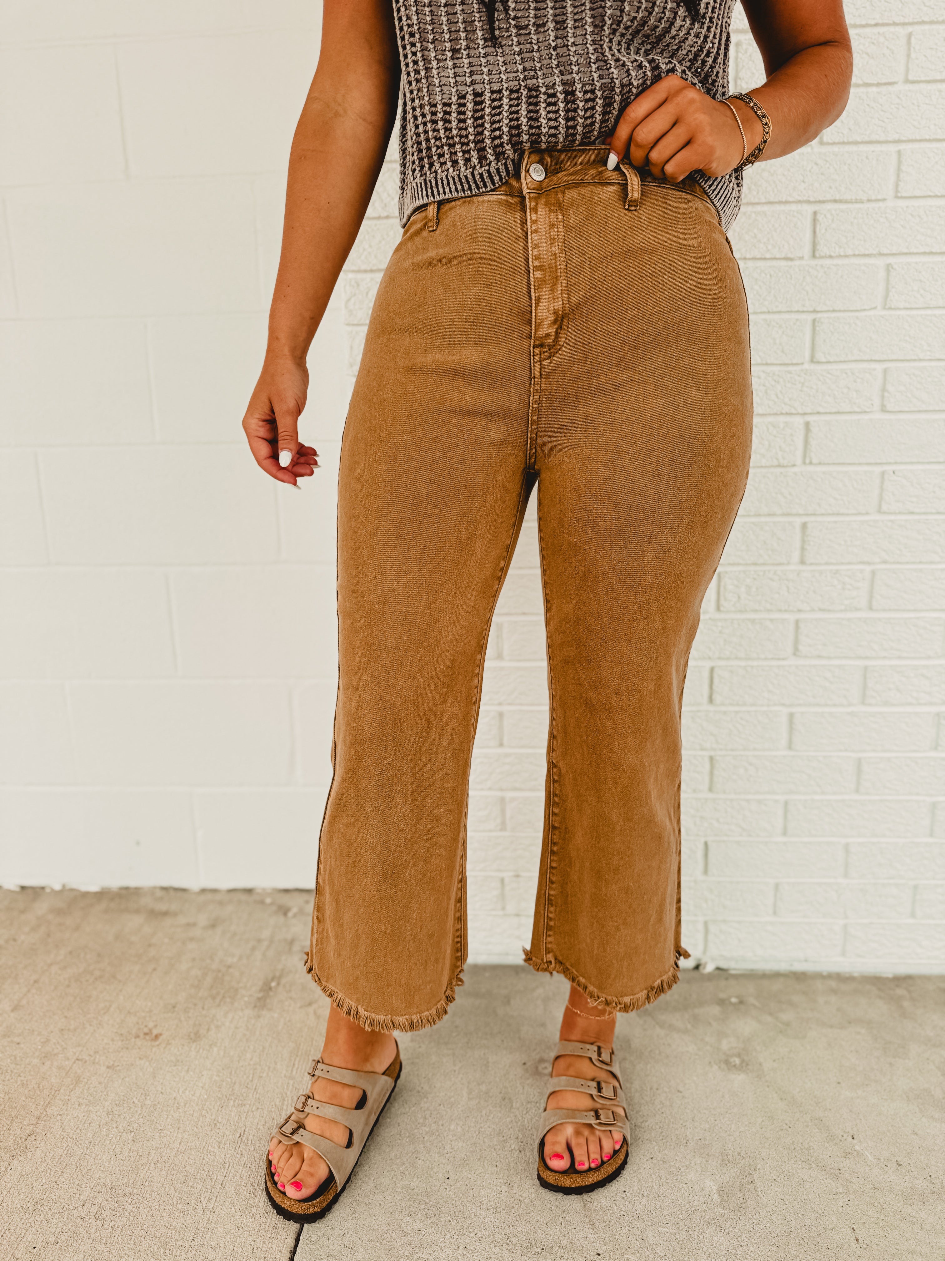 Straight cropped deep camel colored jeans with raw frayed hems.