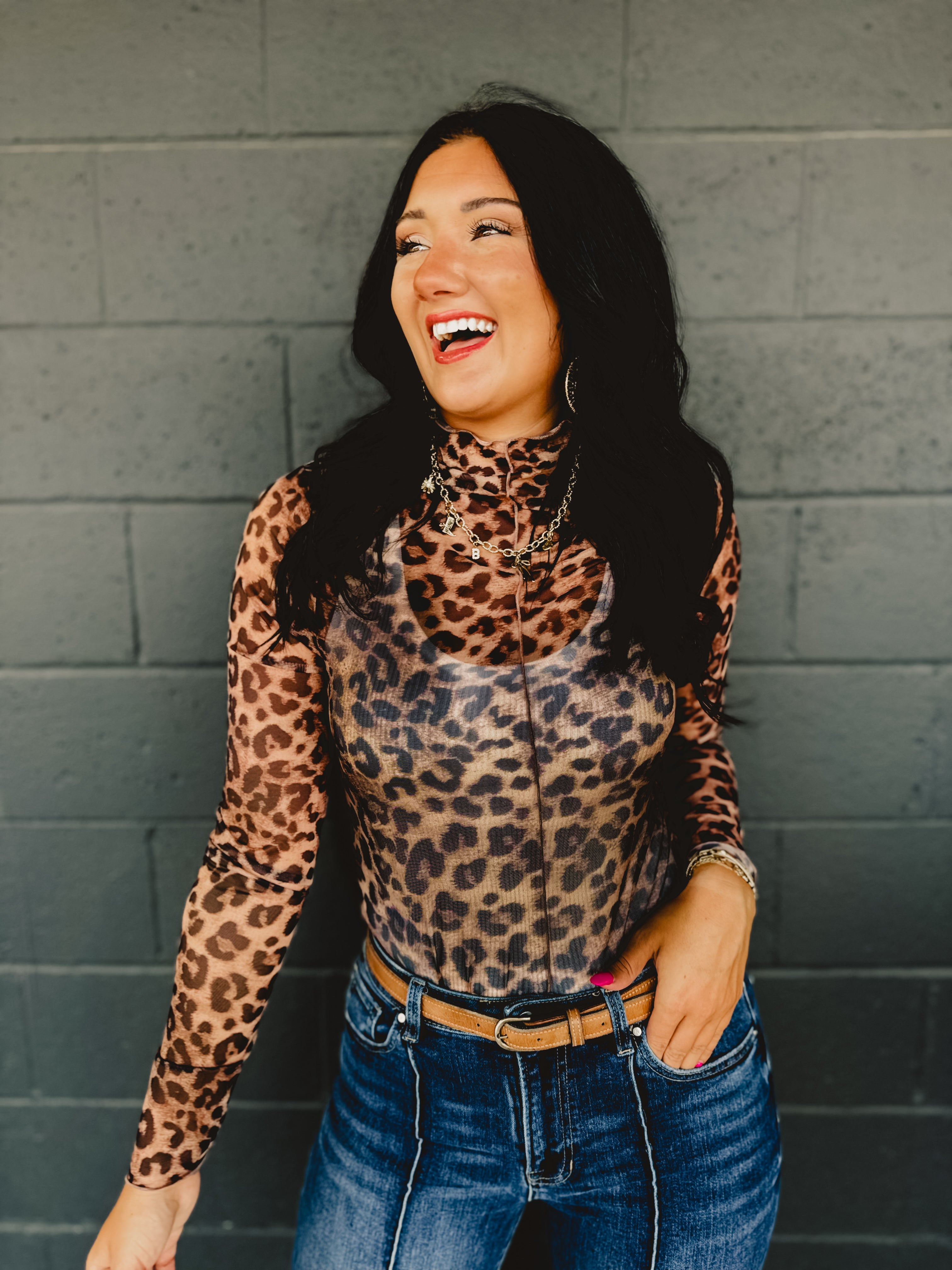 High mock neck long sleeve sheer leopard print top with ruffle hems and a front seam.