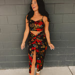 A two-piece satin set featuring a cropped top with a cowl neckline, adjustable spaghetti straps, and zip-up closure, paired with a high-rise midi skirt with a ruched knot waist detail, side slit, hidden zipper, and curve-skimming silhouette.