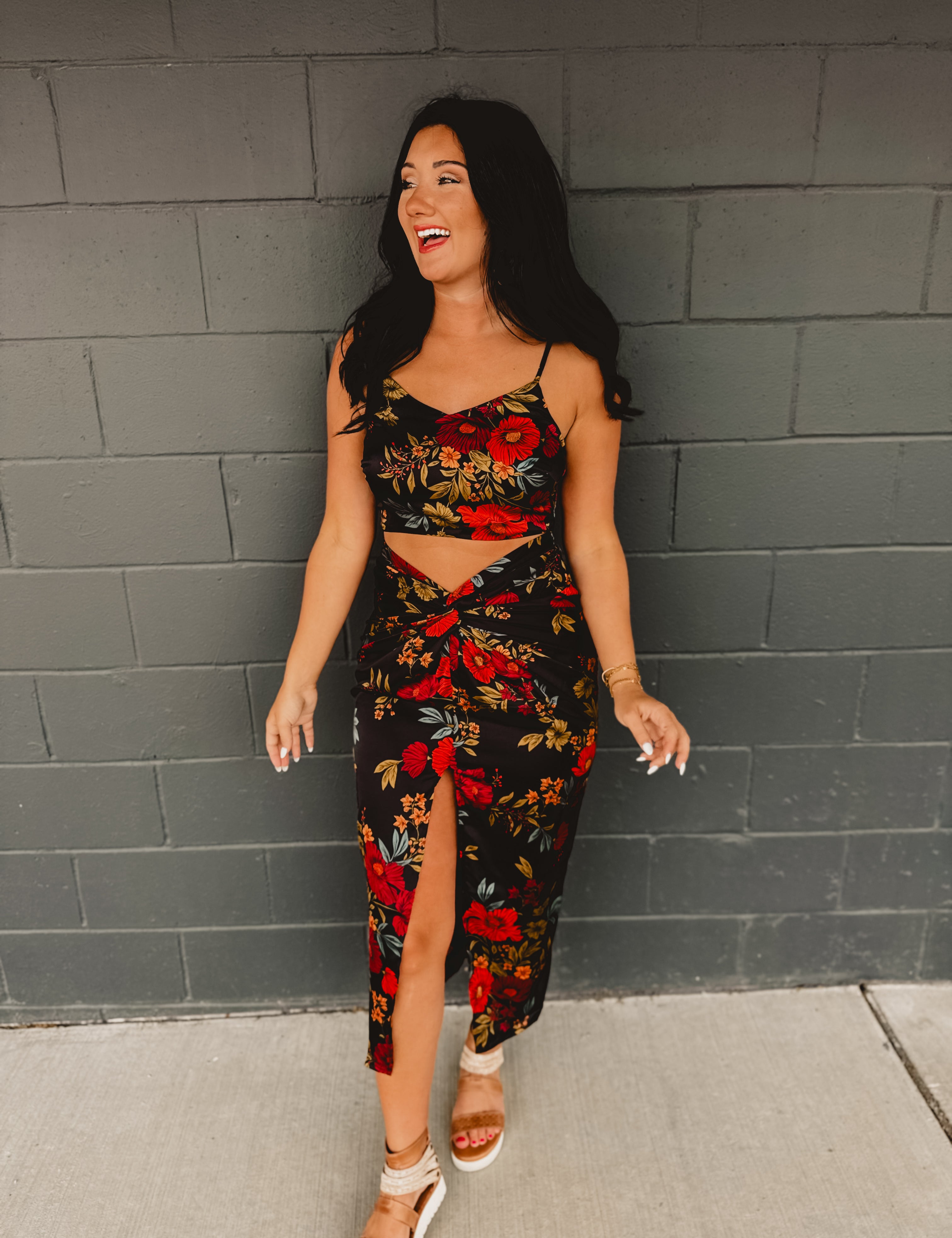 A two-piece satin set featuring a cropped top with a cowl neckline, adjustable spaghetti straps, and zip-up closure, paired with a high-rise midi skirt with a ruched knot waist detail, side slit, hidden zipper, and curve-skimming silhouette.
