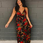 Black satin maxi dress with an empire waist and A-line skirt, featuring adjustable criss-cross back straps, a plunging neckline, and an open-back silhouette.