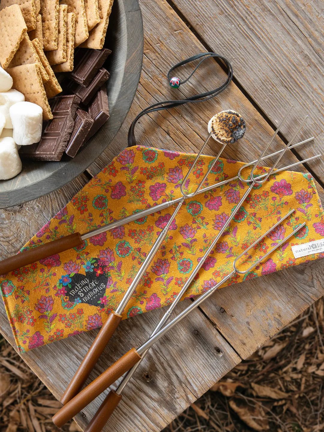 Natural Life campfire roasting sticks including a floral cloth carrier for storage that reads: "Making S'more Memories."