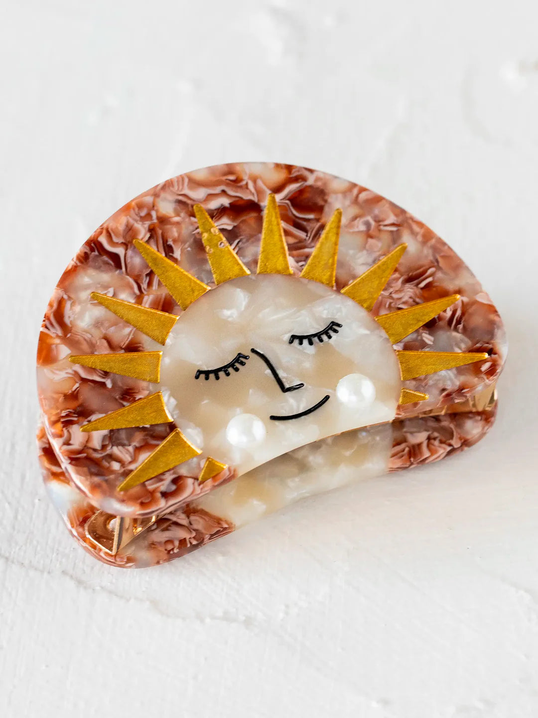 Hair clip with a sun design and pearl accents by Natural Life.