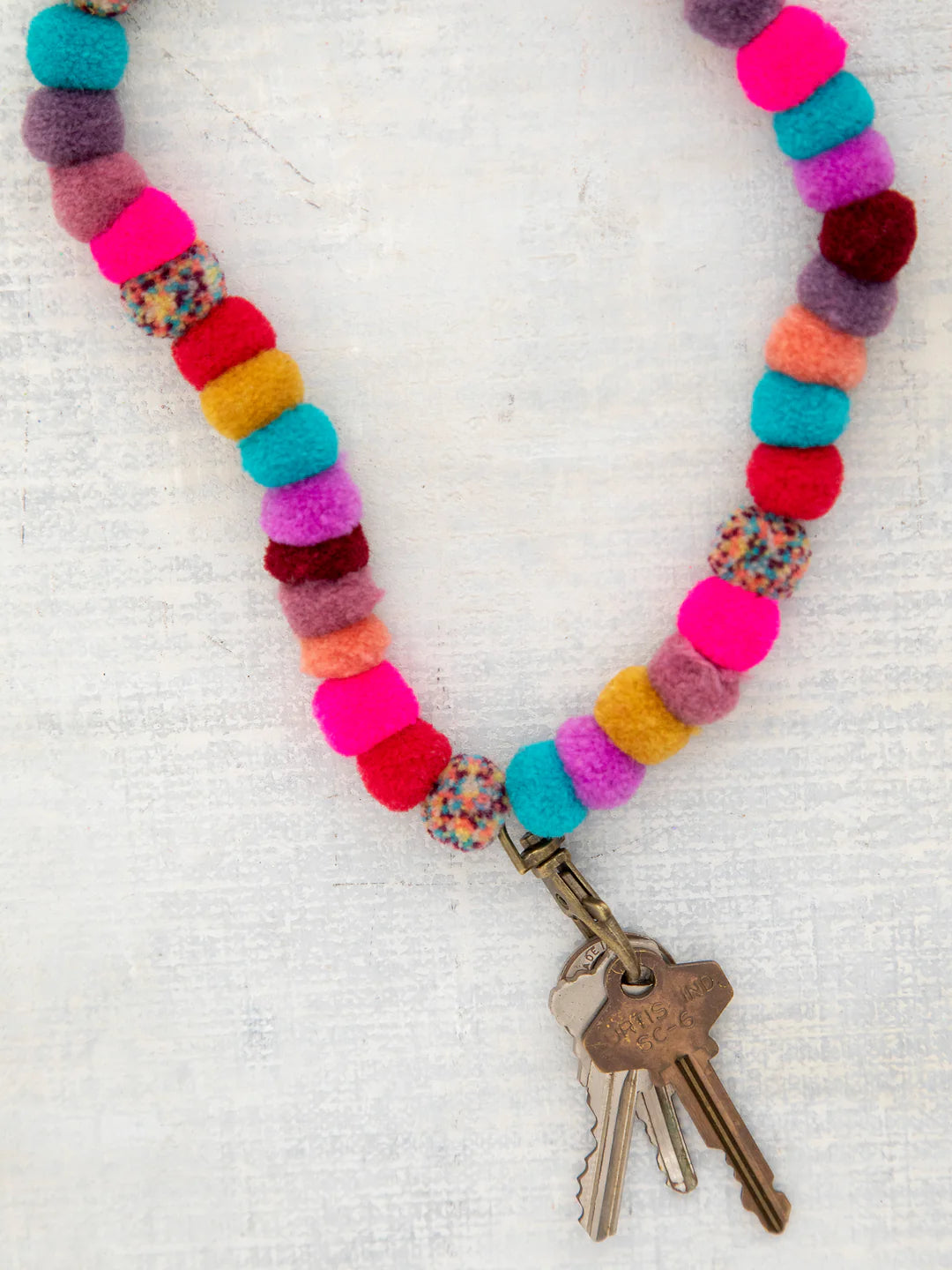 Multicolor Pom Pom lanyard with antique brass clasp by Natural Life.