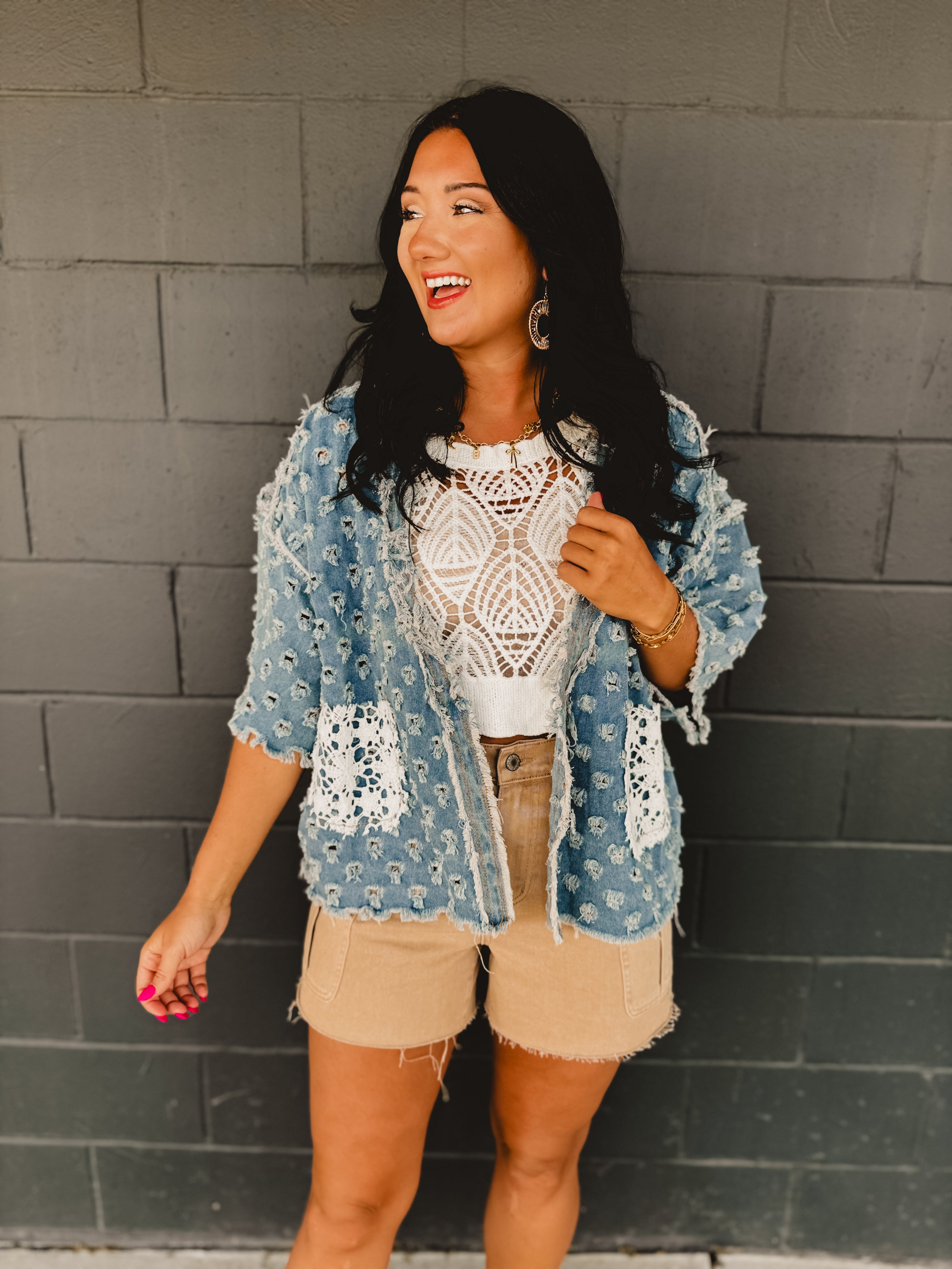 Denim holey open cardigan with white crochet pockets and a v-neck.