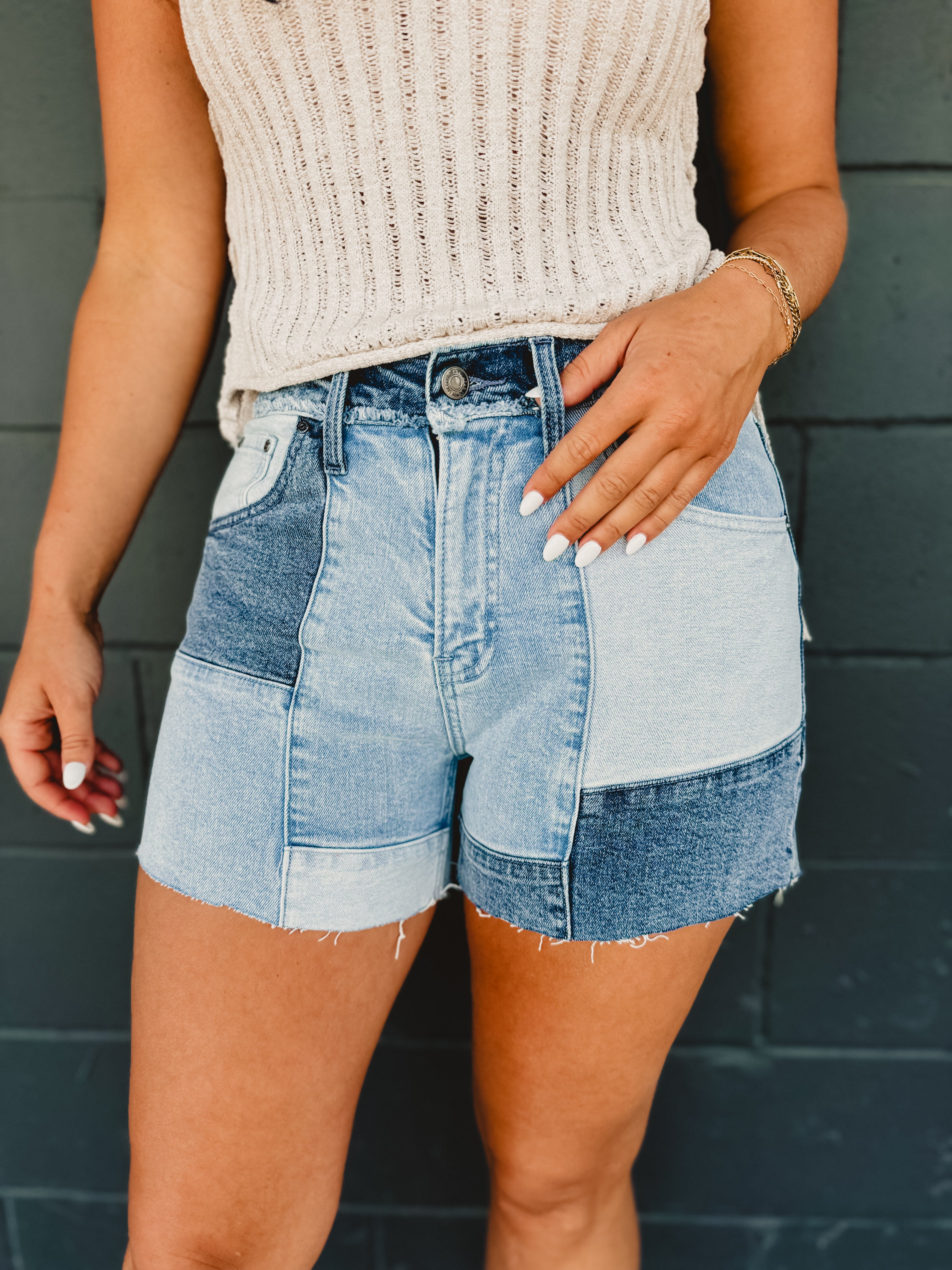 Denim patchwork shorts with zip-up closure and front and back pockets.