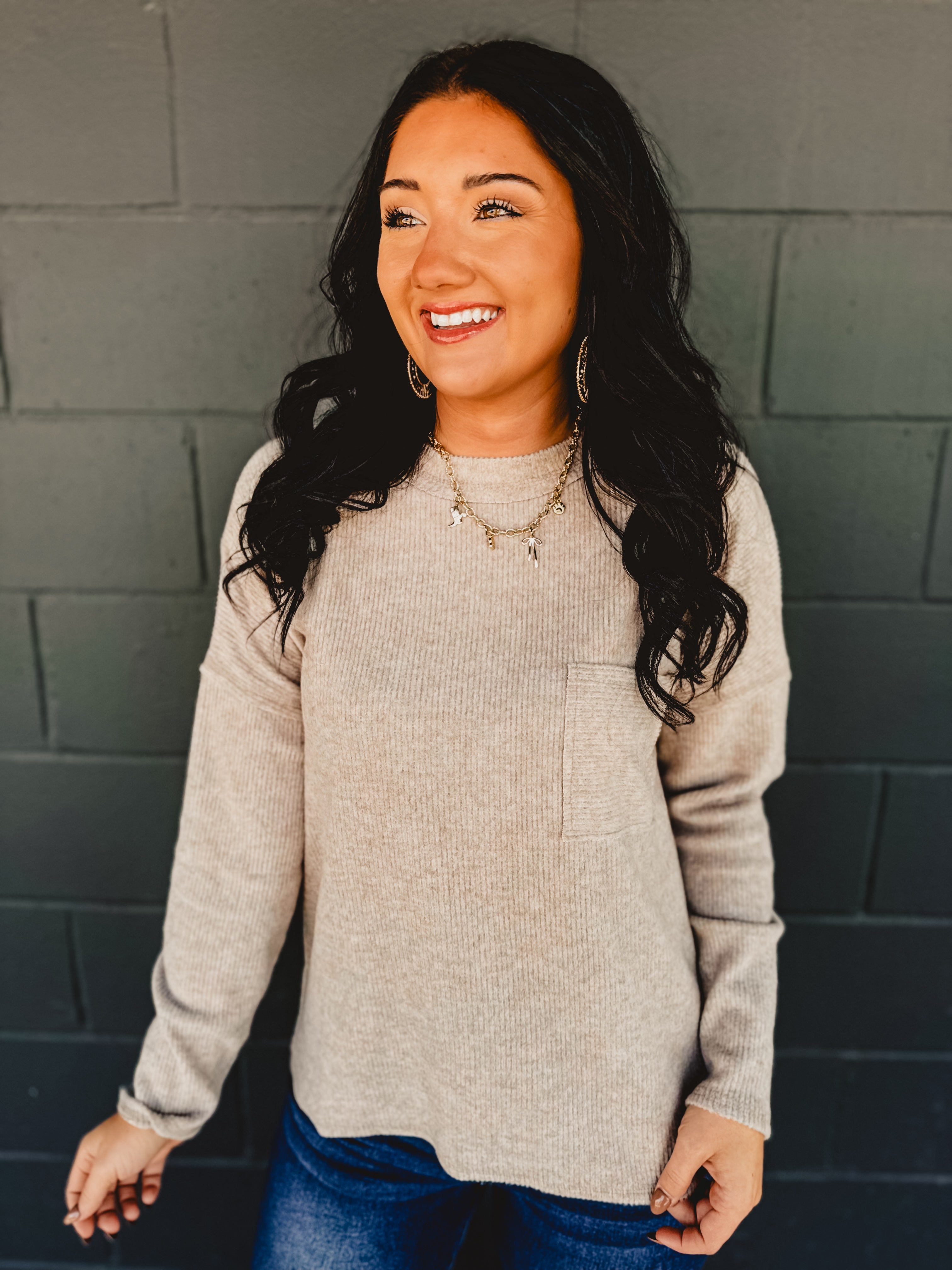 Ribbed brushed long sleeve top in taupe with a front pocket and exposed seams detail.