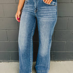 High rise two button wide stitched hem leg jean with front pockets and zip-up closure.