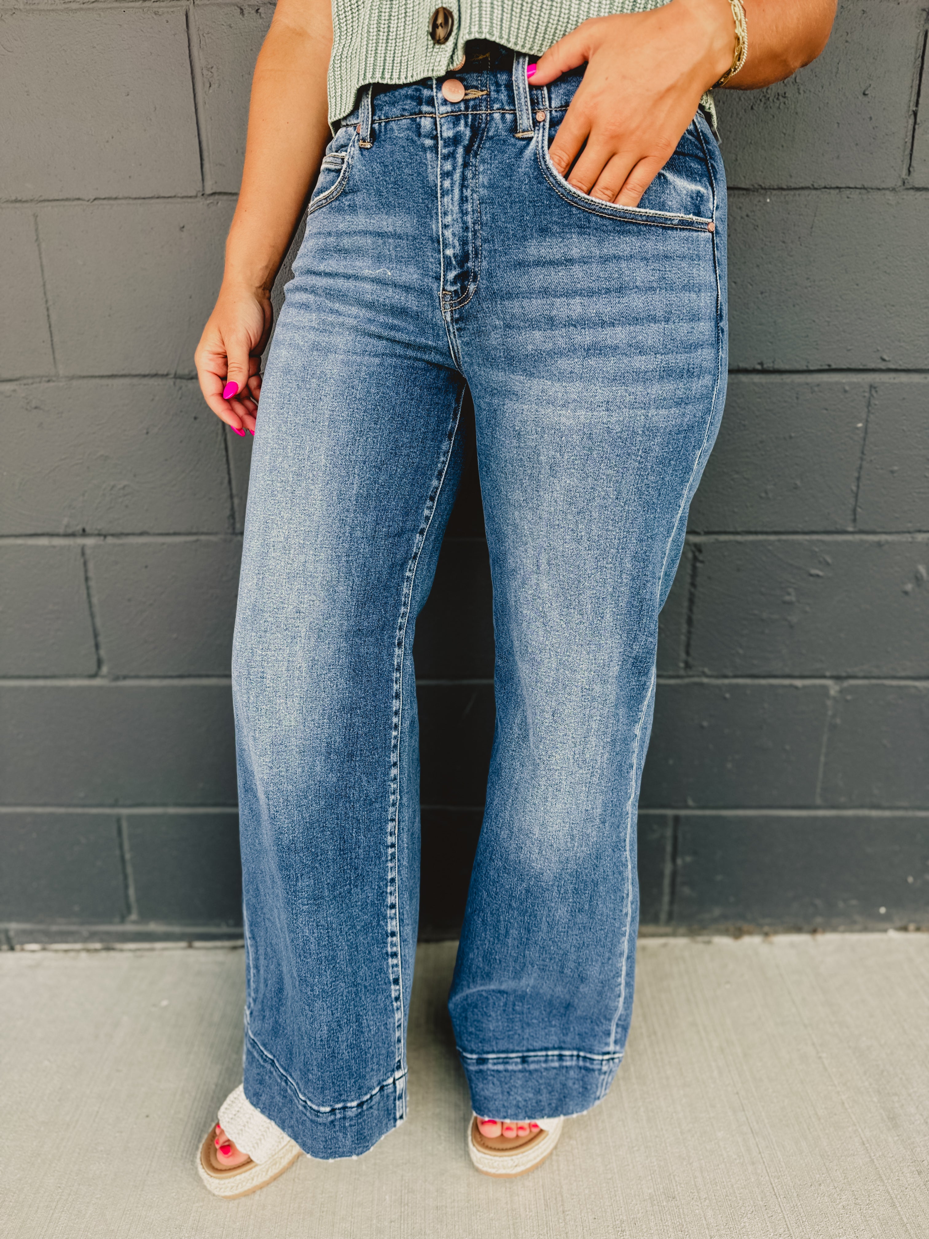 High rise two button wide stitched hem leg jean with front pockets and zip-up closure.