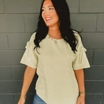 Gauze material oversized short sleeve top with ruched shoulders and bow ties in the color light sage.