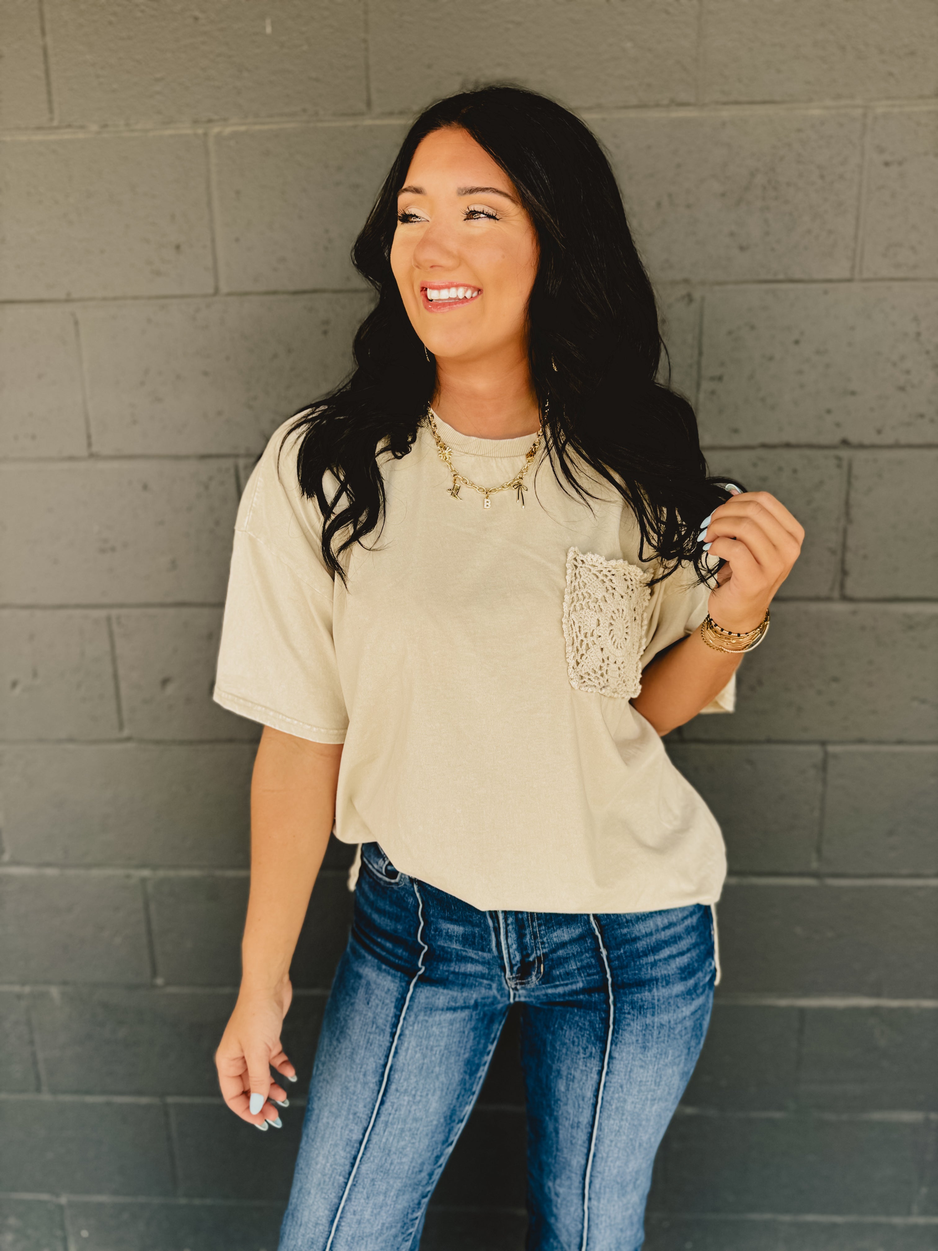 Short sleeved oversized top with drop shoulders, a front crochet pocket, and side slits in khaki.