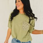 Oversized green top with crochet pocket with a boxy silhouette.