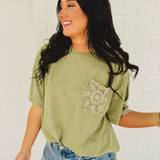 Oversized green top with crochet pocket with a boxy silhouette.