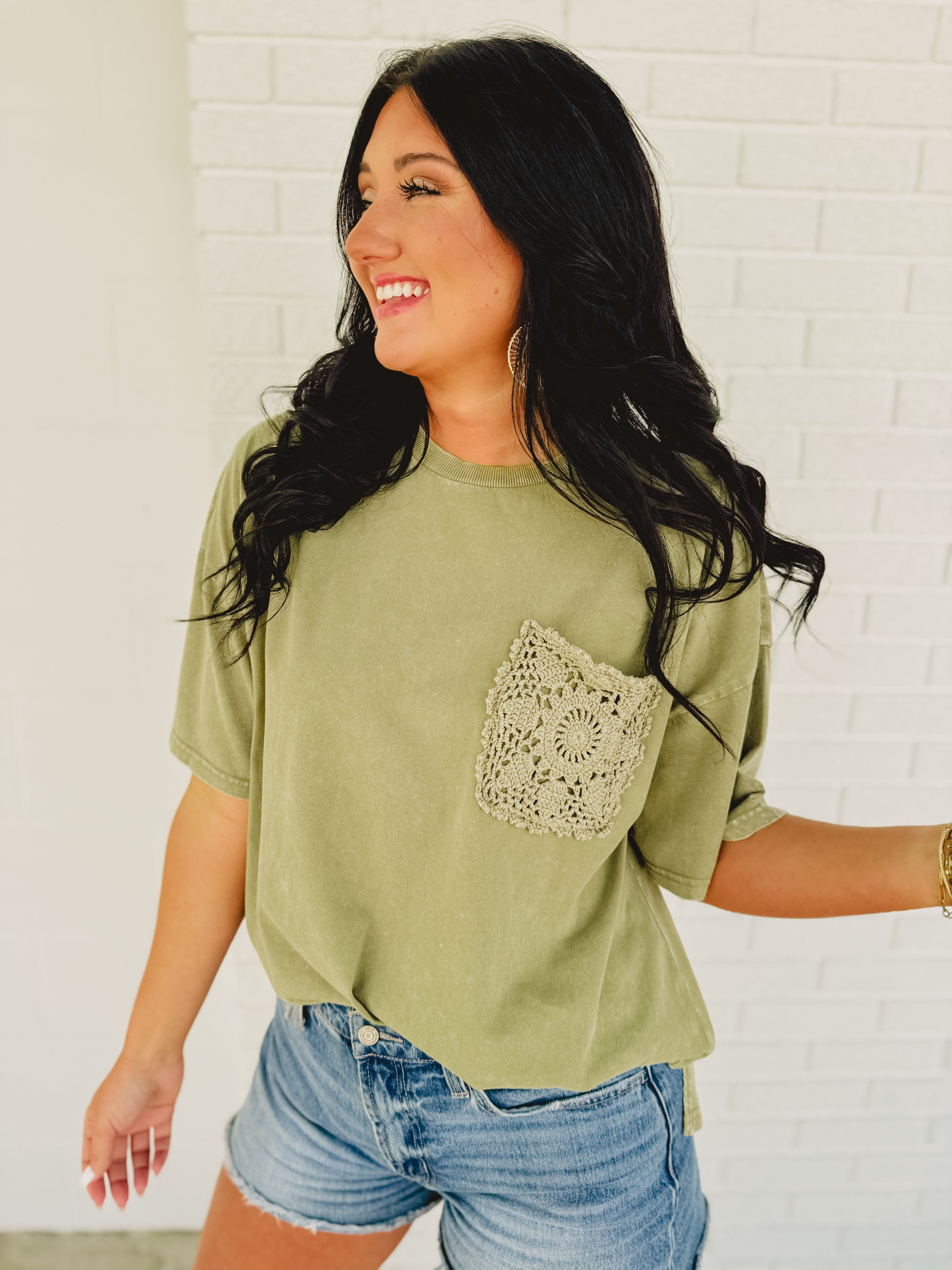 Oversized green top with crochet pocket with a boxy silhouette.