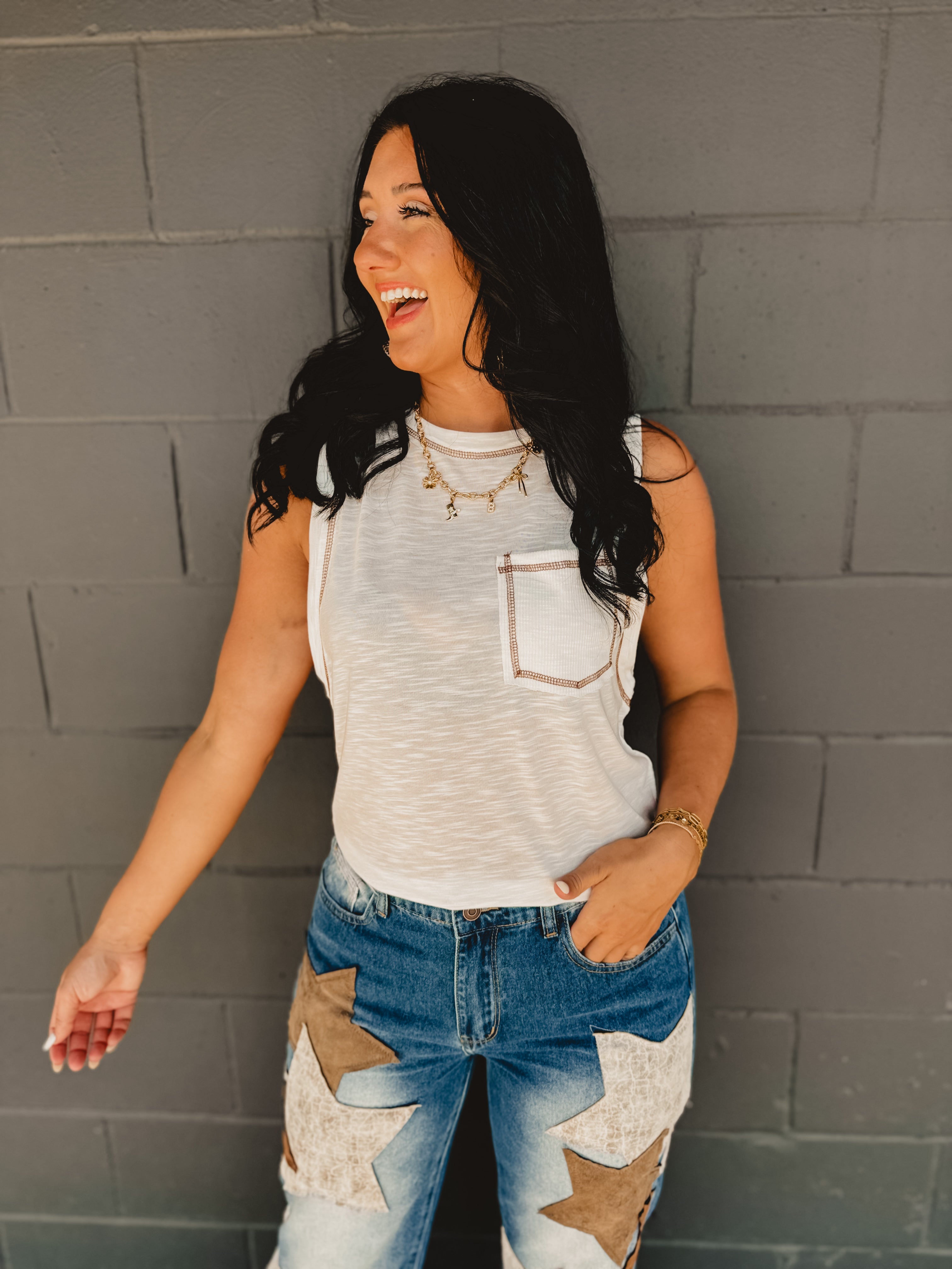 Sleeveless stitch detail and front pocket tank top in off white.