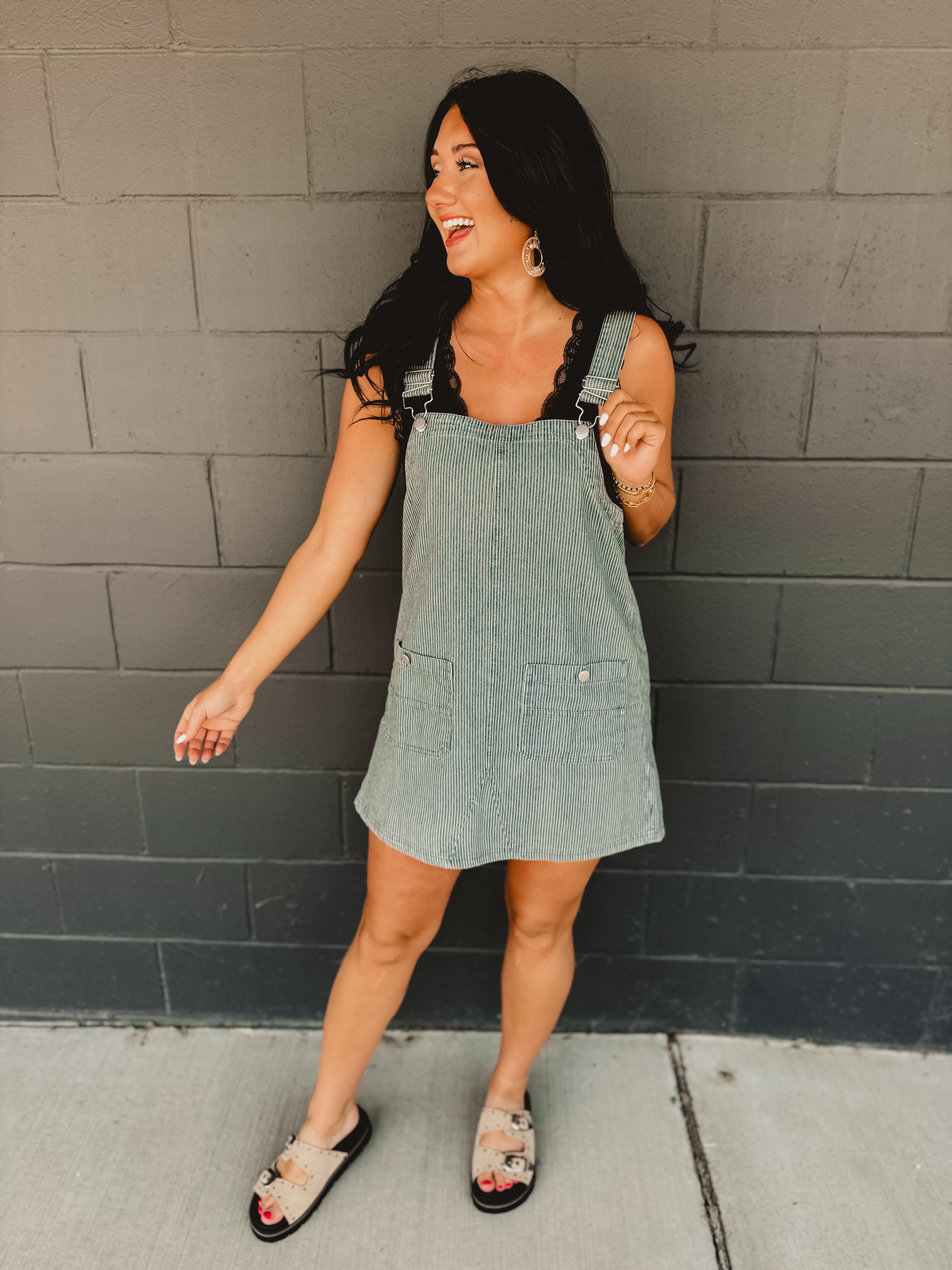 Striped overall mini length dress with front pockets and straps.