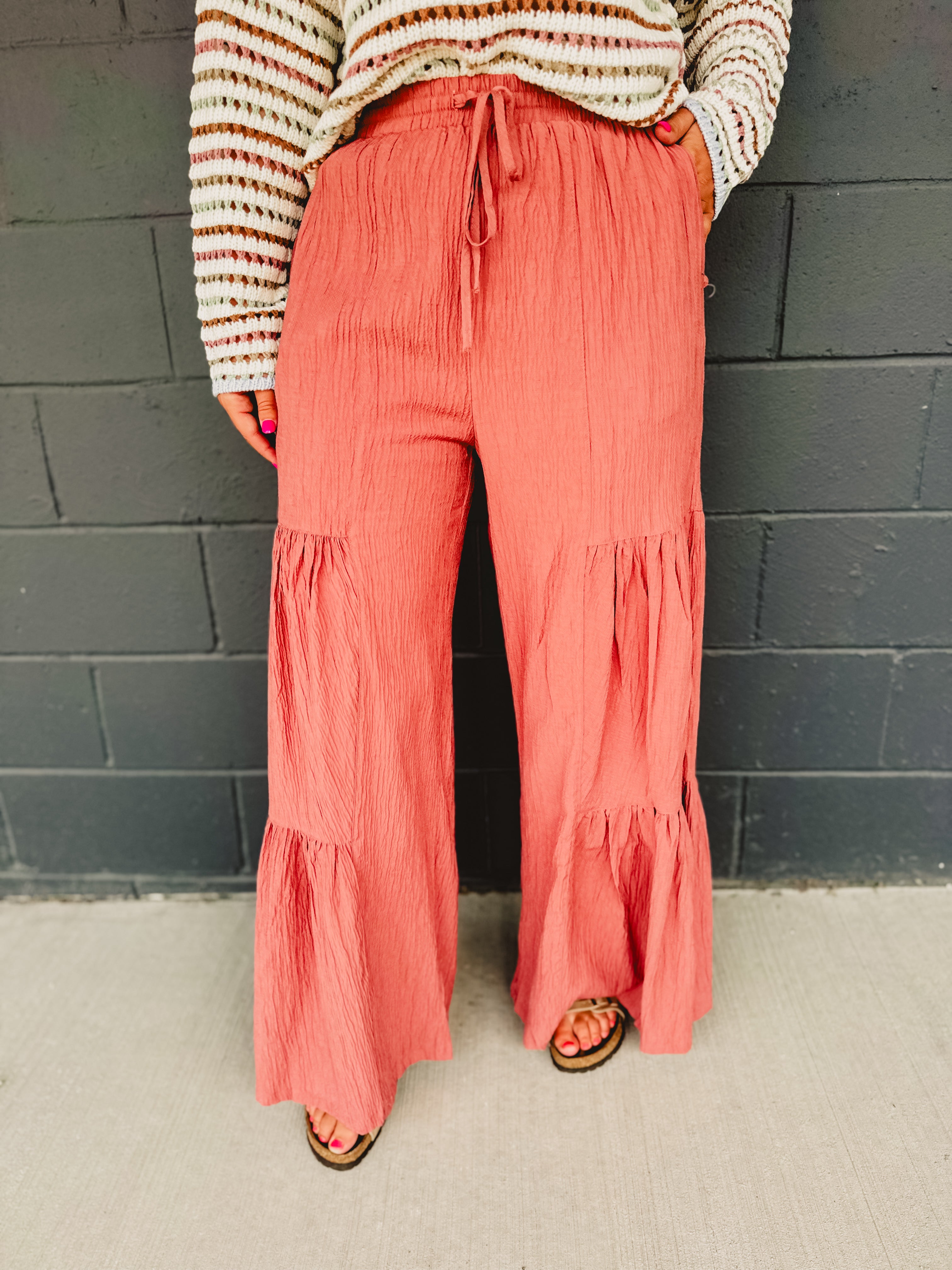 Tired textured wide leg pants with an elastic waistband and drawstrings in dried rose.