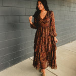 Long sleeved tiered brown floral maxi dress with a v-neck and fitted waistband.