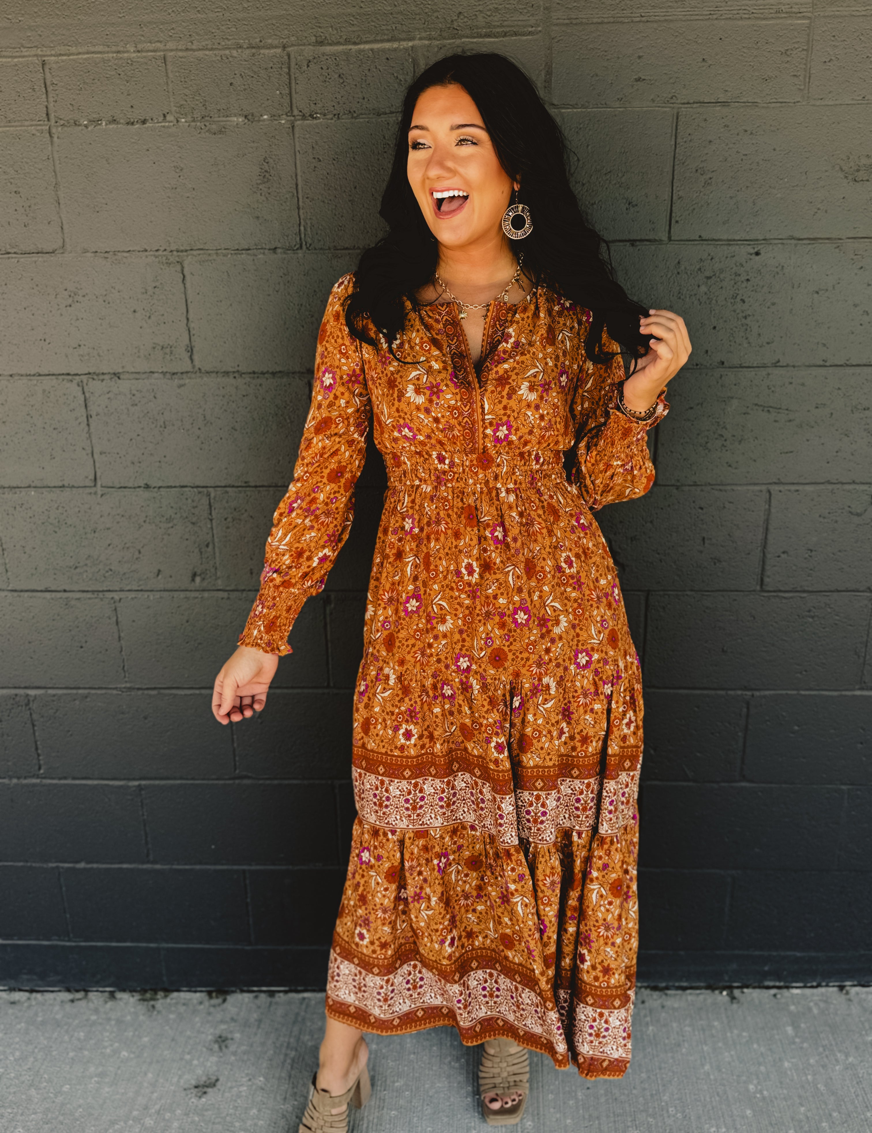 Border printed long sleeve maxi dress with a split neck and smocked waistband in the color pumpkin.