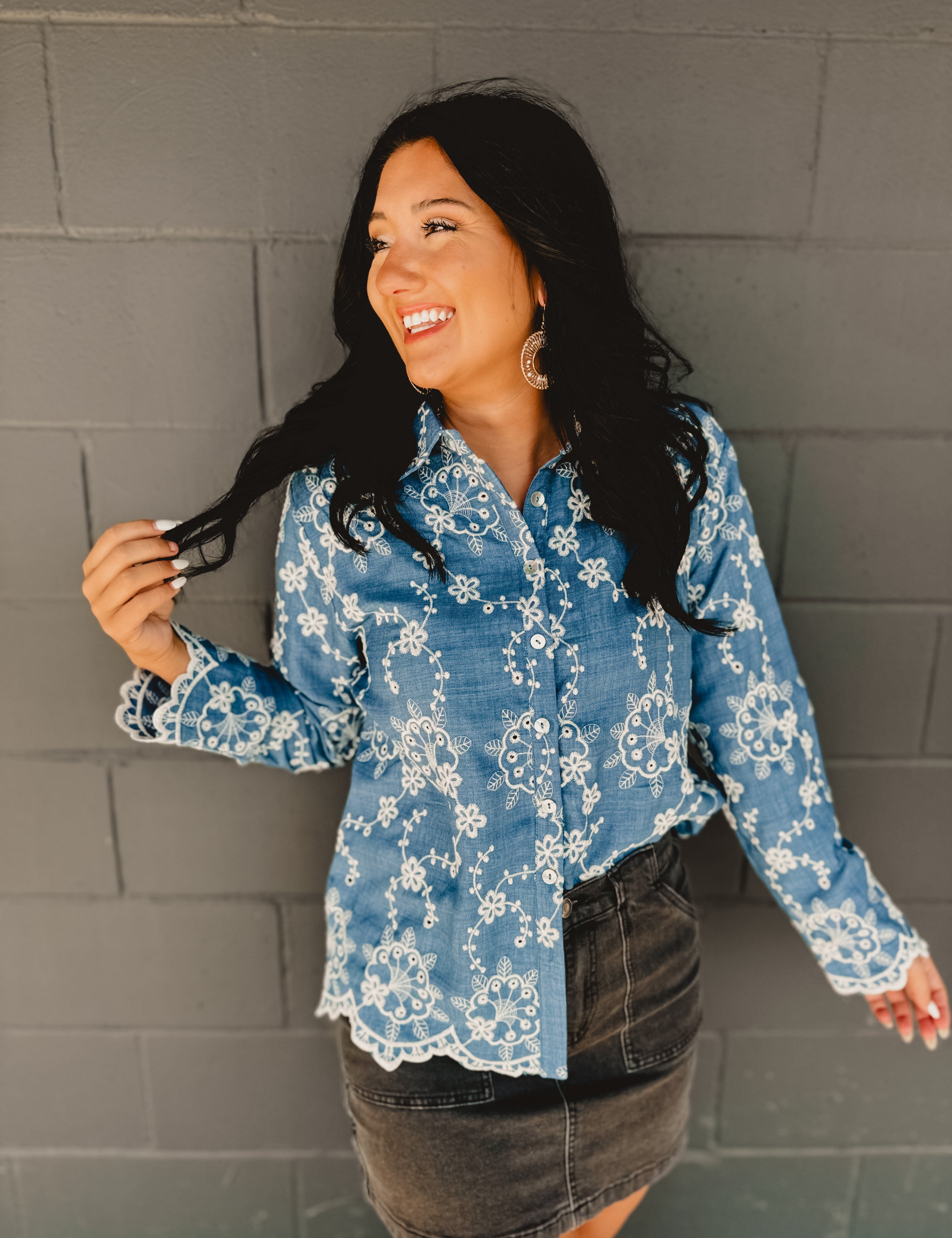 Blue denim flower embroidered long sleeve button down top with scalloped edge hemming and a collar.