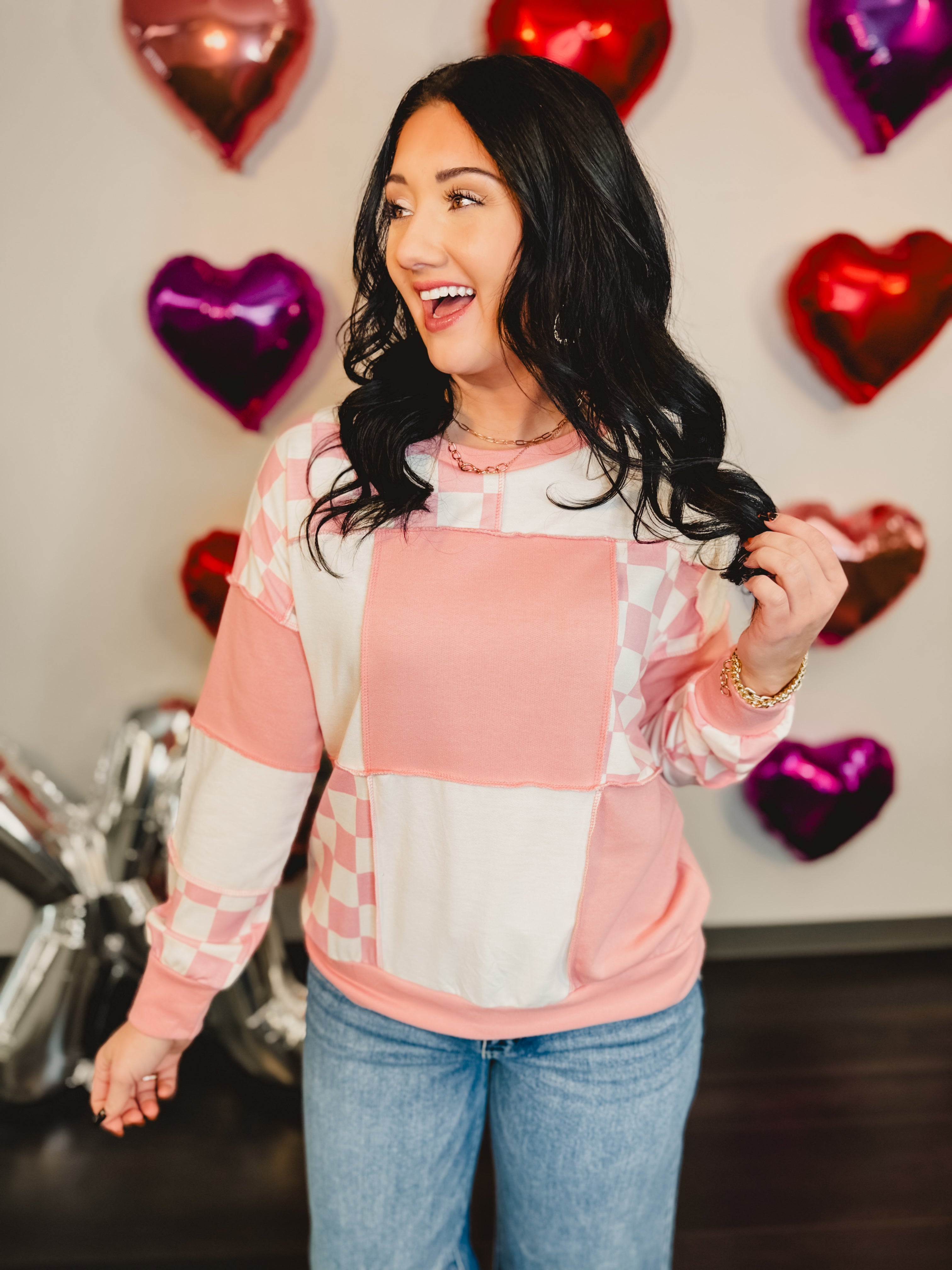 Checkered patchwork round neck long sleeve pullover top in pink and white.