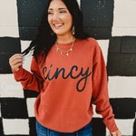Long sleeve round neck orange Cincy sweatshirt.