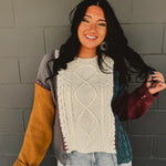 Color block cable knit sweater with exposed stitching in beige multi.