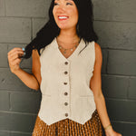 Sleeveless v-neck button-up cotton linen blend vest in natural with adjustable waist features and breathability.