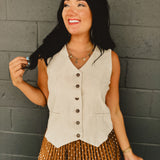 Sleeveless v-neck button-up cotton linen blend vest in natural with adjustable waist features and breathability.