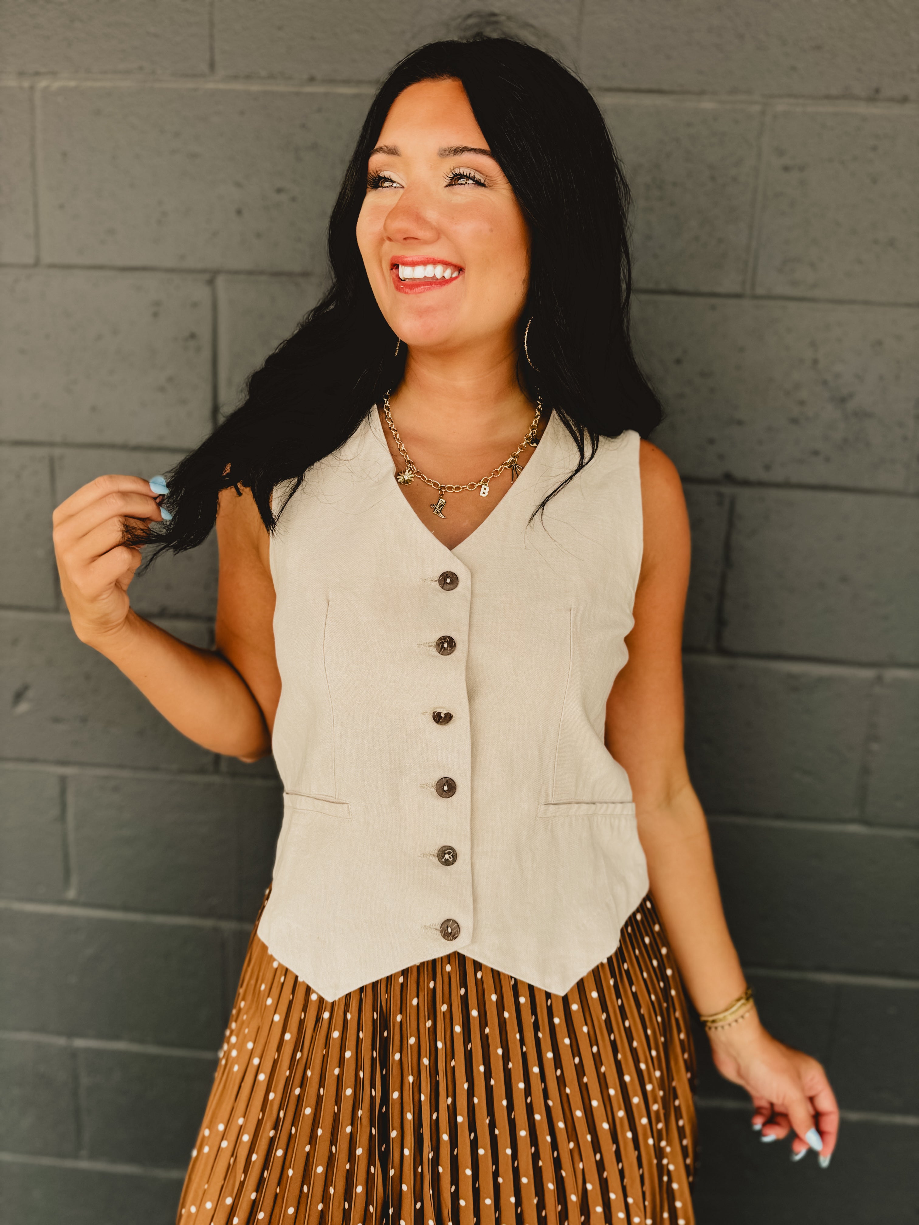 Sleeveless v-neck button-up cotton linen blend vest in natural with adjustable waist features and breathability.