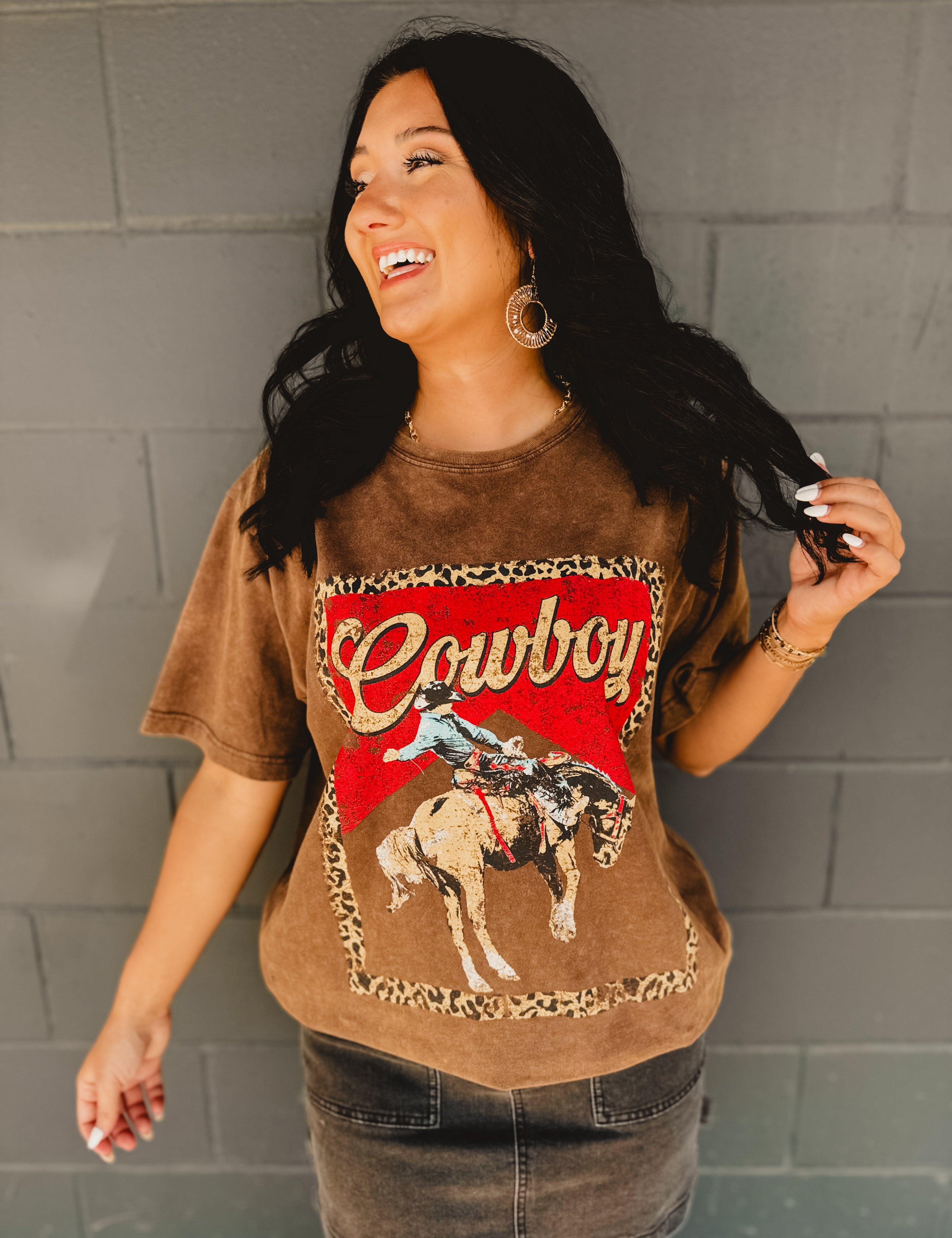 Short sleeve rounded neck brown mineral washed Cowboy graphic tee with cheetah print and a man riding a horse graphics.