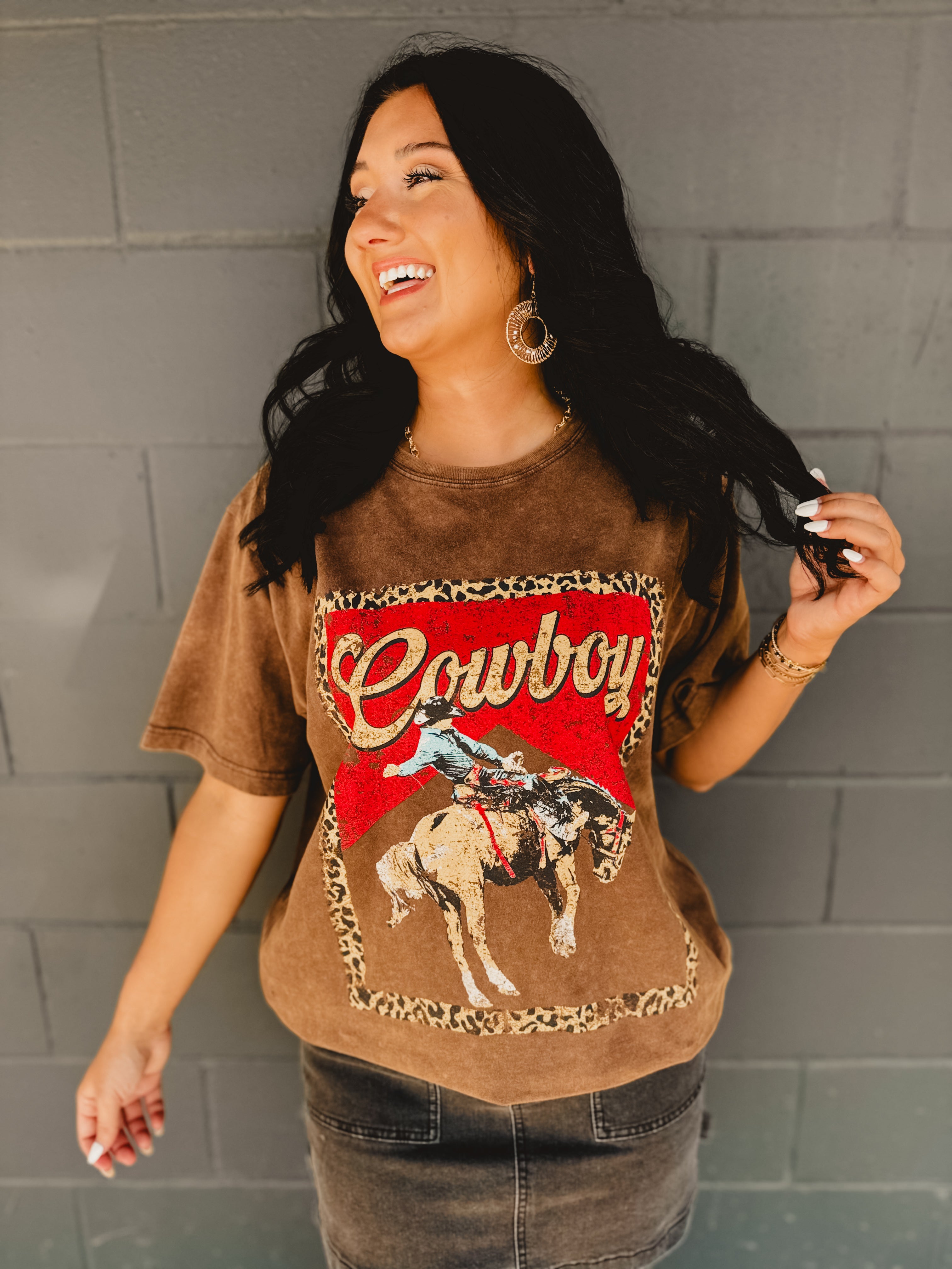 Short sleeve rounded neck brown mineral washed Cowboy graphic tee with cheetah print and a man riding a horse graphics.