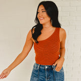 Cropped one shoulder knit crop top in the color rust.