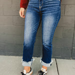 Mid-rise distressed cuffed straight leg jeans in dark denim.