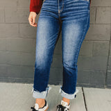 Mid-rise distressed cuffed straight leg jeans in dark denim.